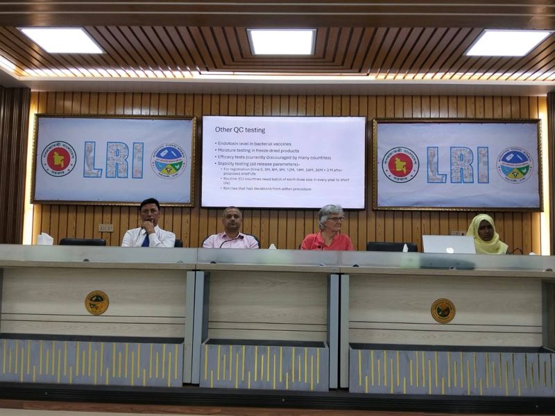Panel at an LRI seminar with a slide on quality-control testing of vaccines